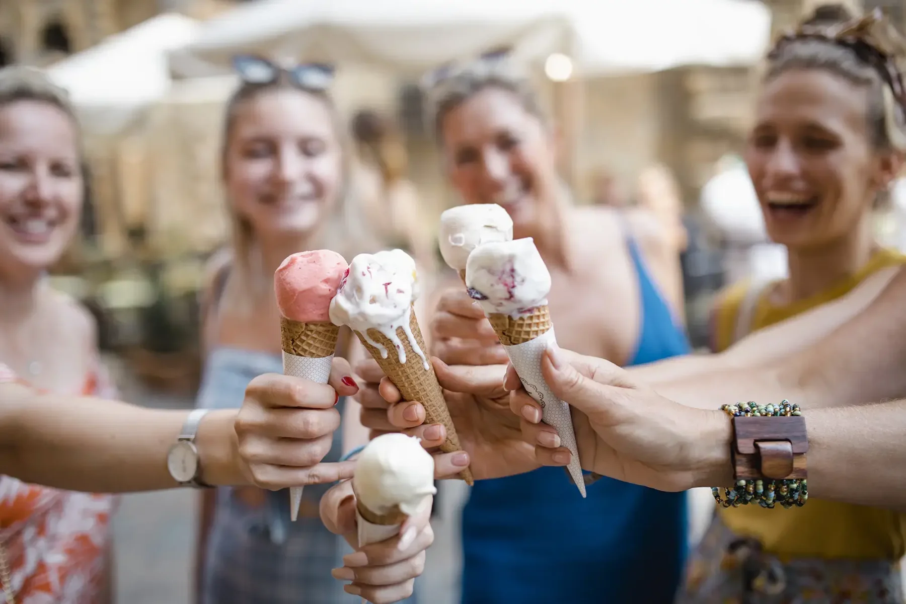 Group of friends with ice cream cones clinking them together like a toast