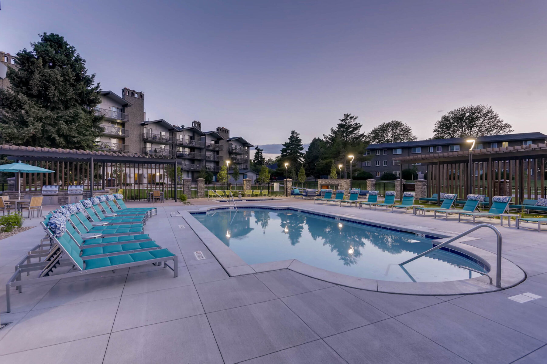 Pool with deck seating and grilling stations nearby